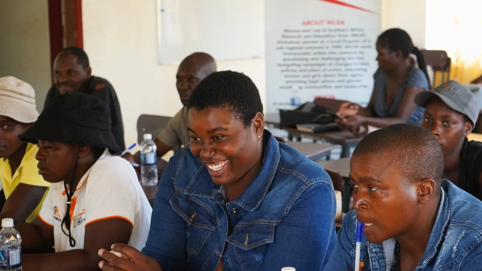 Woman smiling during WLSA Zimbabwe community empowerment workshop